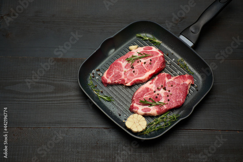 Fresh raw beef or pork steaks on frying pan