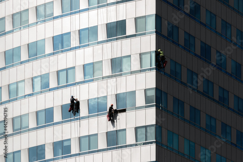peope cleaning windows of a high-rise building photo