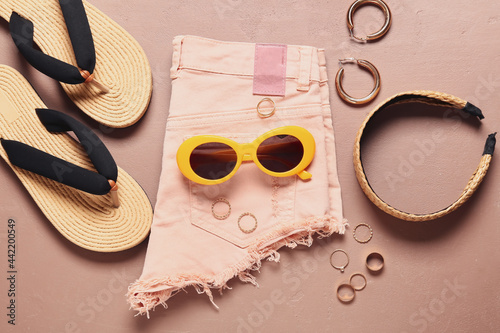 Set of female accessories with sunglasses on color background