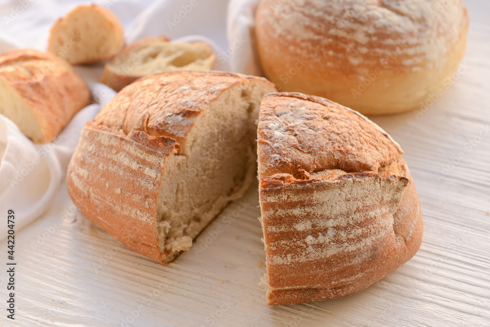 Loaf of sourdough bread on white wooden background