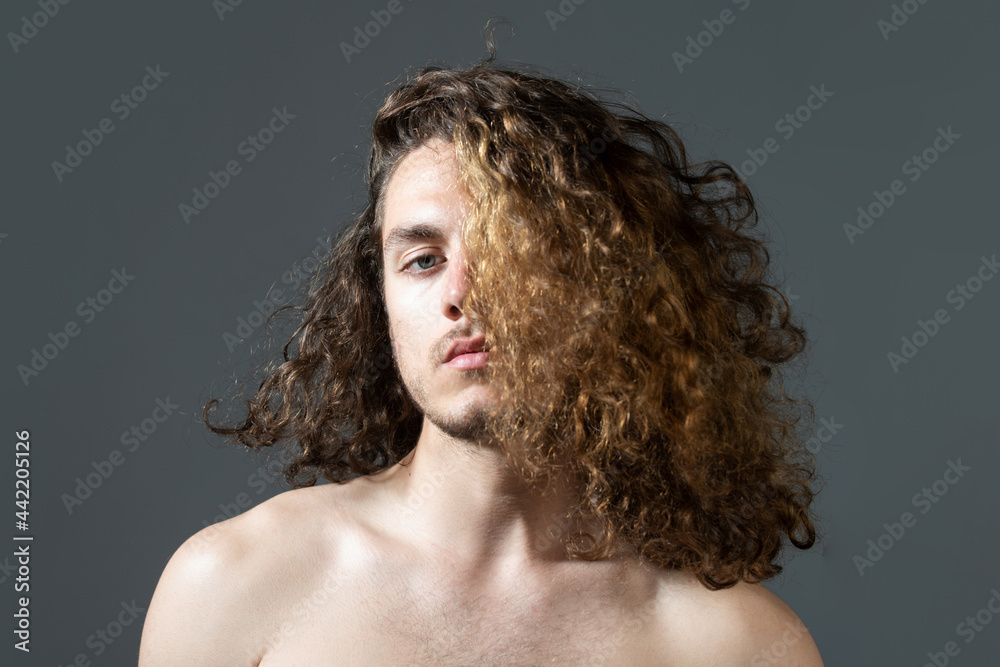Man with long curly hair, haircut, modern hair style. Close up portrait of male model with long hair. Healthcare and hair care concept. Man with long curly hair, haircut, modern hair style. Close up portrait of male model with long hair. Healthcare and hair care concept.