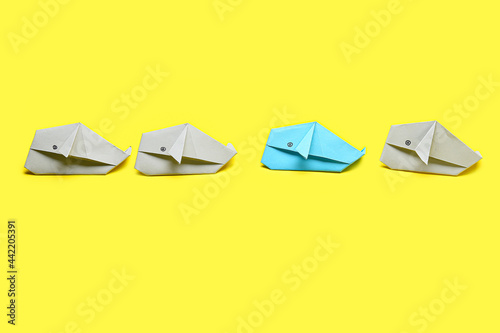 Origami whales on color bac...