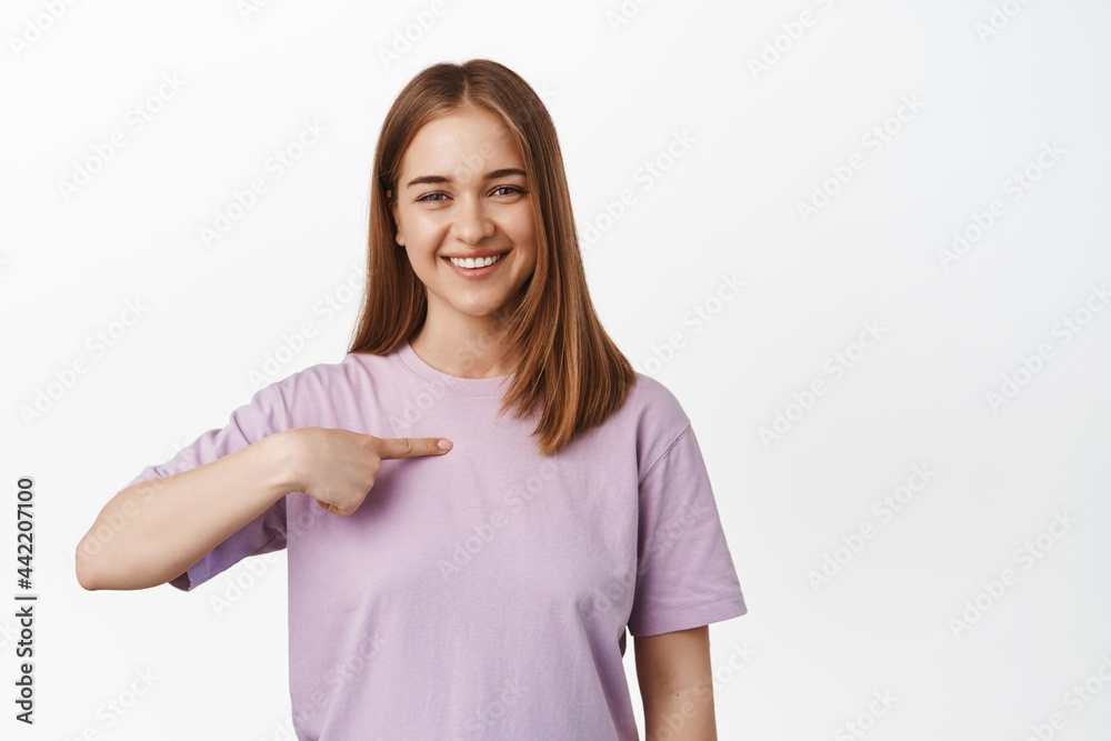 Its me. Smiling blond girl pointing at herself, volunteering, asking to participate, bragging, talking about her achievements, standing over white background Its me. Smiling blond girl pointing at herself, volunteering, asking to participate, bragging, talking about her achievements, standing over white background