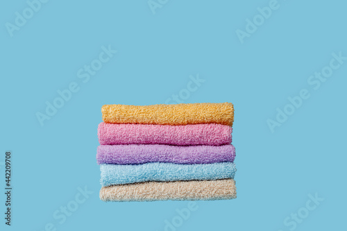 set of multi-colored towels on a blue background. spa concept. health care and beauty.