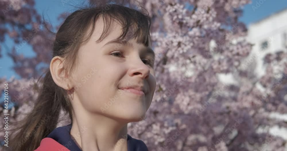 Walk in blooming spring park. A child relax with aroma of spring tree flowers in the park.
