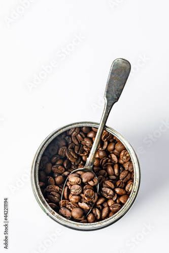 Tin can with coffee beans. An open jar with roasted aromatic arabica on a white background Traditional morning drink. Copy space. Coffee time theme. Top view