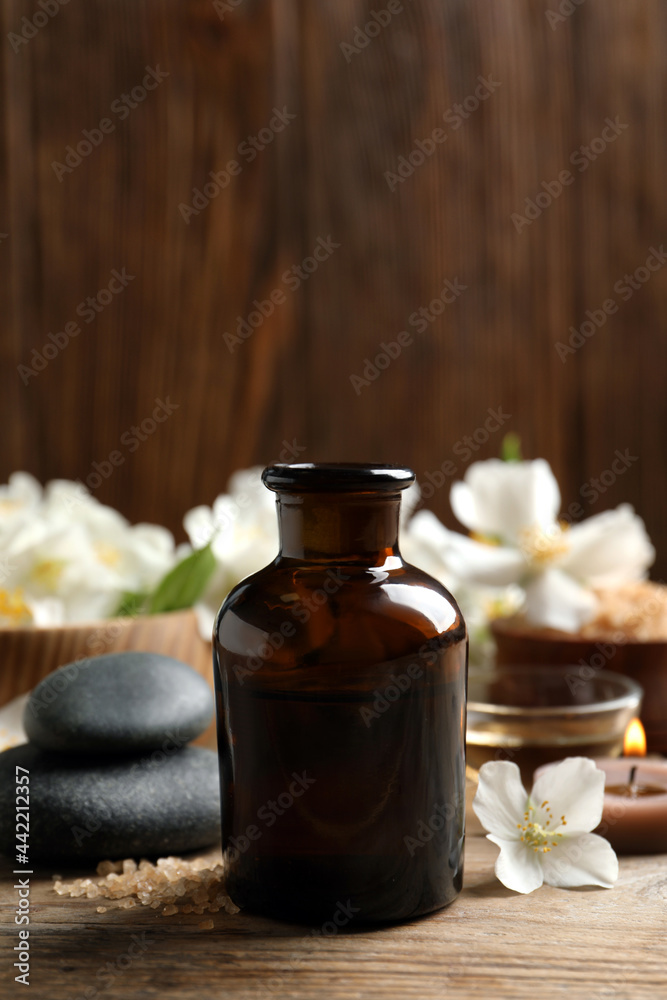 Beautiful composition with jasmine essential oil and fresh flowers on wooden table Beautiful composition with jasmine essential oil and fresh flowers on wooden table