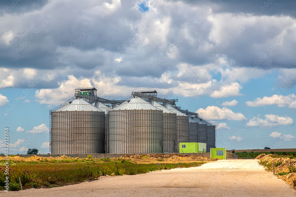 Landscape with modern agricultural Silo. Set of storage tanks cultivated agricultural crops processing plant.
