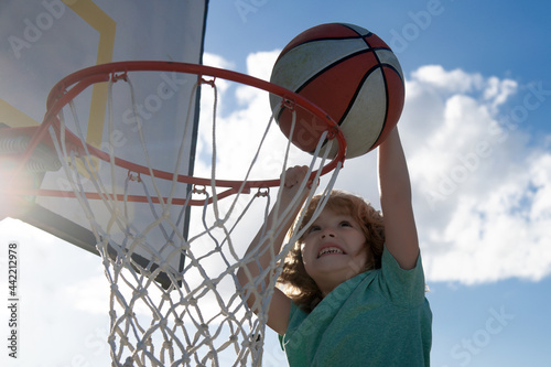 Kids playing basketball. Child sport activity. Healthy children lifestyle. Closeup face of kid basketball player making slam dunk.