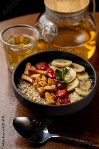 Summer fruity oatmeal with honey, berries, banana, apples and cinnamon