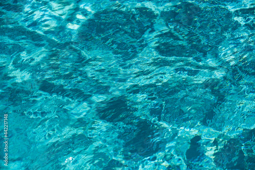 Water background, ripple waves. Blue swiming pool pattern. Sea surface. Water in swimming pool with sun reflection. Banner with copy space.