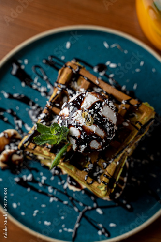 Hot and soft viena waffles with a scoop of vanilla ice cream and chocolate topping  top view
