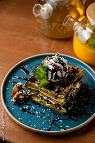 Hot and soft viena waffles with a scoop of vanilla ice cream and chocolate topping, top view