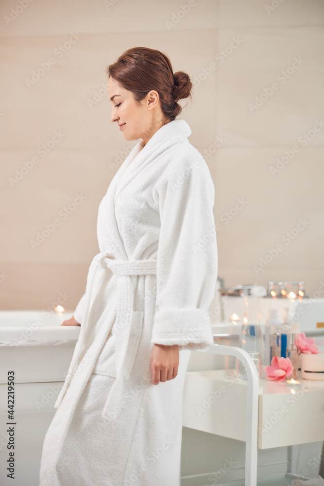 Cute Caucasian woman is staying alone in spa salon