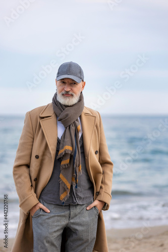 an aged man walking along the beach against the background of the sea © zokov_111