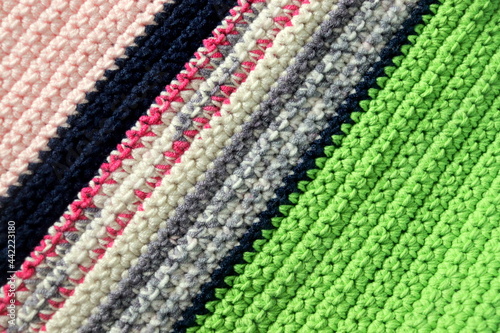 Knitted background, knitted wallpaper, knitted fabric, ricotted texture. Soft material. Handmade carpet closeup photo. Cozy background. Knitted details. 