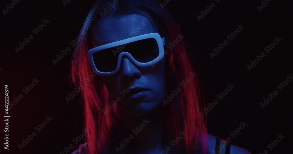 Close up portrait of retro wave 80s fashion men hipster with long hair takes off his glasses looks into camera in neon dark background. Cyberpunk futuristic stylish computer game of movie character Close up portrait of retro wave 80s fashion men hipster with long hair takes off his glasses looks into camera in neon dark background. Cyberpunk futuristic stylish computer game of movie character