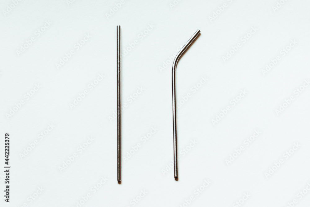Two metal reusable straws for drinks on a white background. Two metal reusable straws for drinks on a white background.