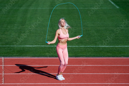 energetic woman jumping with rope. sporty girl in sportswear jump on skipping rope.