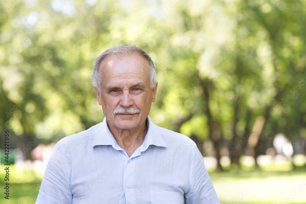 Portrait Elderly man smiling and looks in the camera outdoors. real people Portrait Elderly man smiling and looks in the camera outdoors. real people