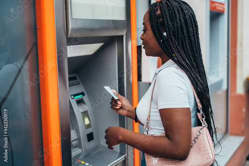 African american woman using atm machine and a credit card photo