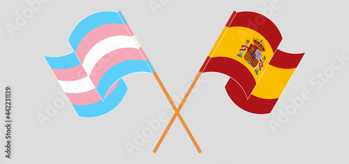 Crossed and waving flags of transgender pride and Spain