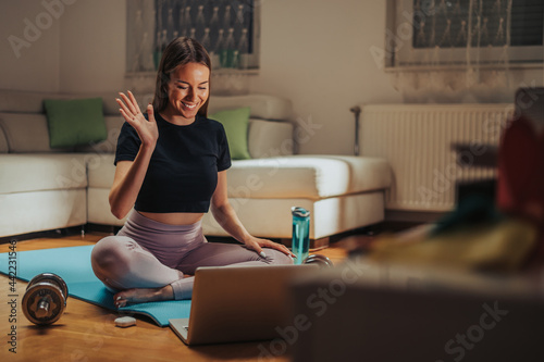Woman using laptop while having an online fitness training while at home