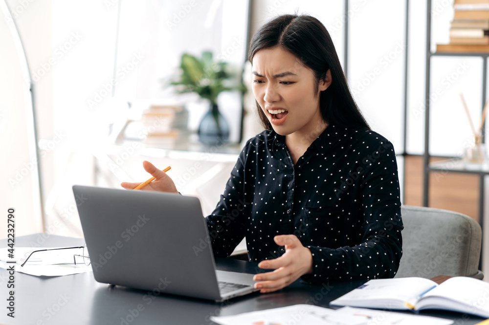 Unpleasant video conversation. Annoyed asian girl, ceo, office worker, irritated talking with colleague on video call, scolding for poorly performed work, unhappy facial expression,angry female leader