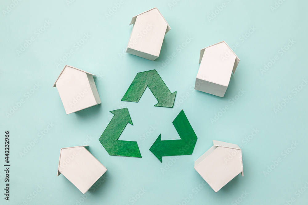 Saving energy eco friendly global warming concept. Simply design with miniature white toy model houses and recycling symbol isolated on pastel blue background. Flat lay top view copy space. Saving energy eco friendly global warming concept. Simply design with miniature white toy model houses and recycling symbol isolated on pastel blue background. Flat lay top view copy space.