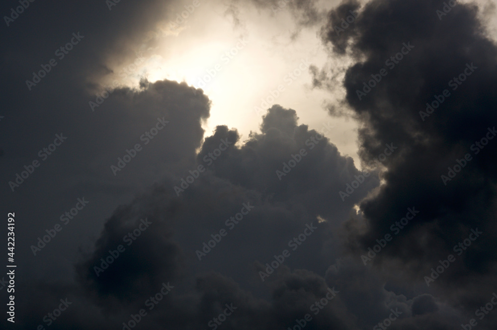 Thick storm clouds fill the sky and surround the sun, obscuring it from view. Thick storm clouds fill the sky and surround the sun, obscuring it from view.