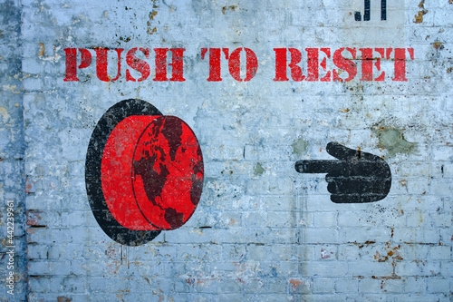 Push to reset world graffiti on grungy wall, the great reset concept photo