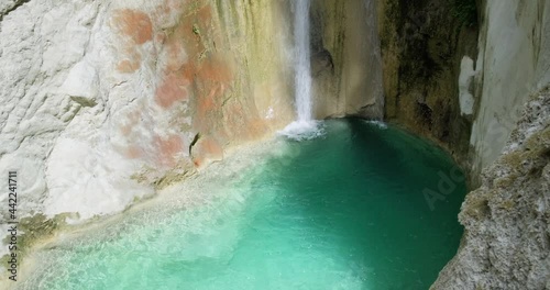 Panning shot of small waterfall of Nidri and natural pool with emerald water.
