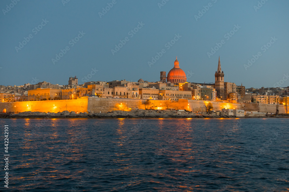 Night landscape of Valetta skyline in Malta. The stunning skyline of old Valletta, its churches and towers, its historic remparts from the Northern Harbour on blue hour