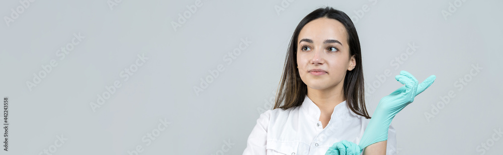 A girl doctor in latex gloves and a white coat is preparing for the procedures. A girl doctor in latex gloves and a white coat is preparing for the procedures.