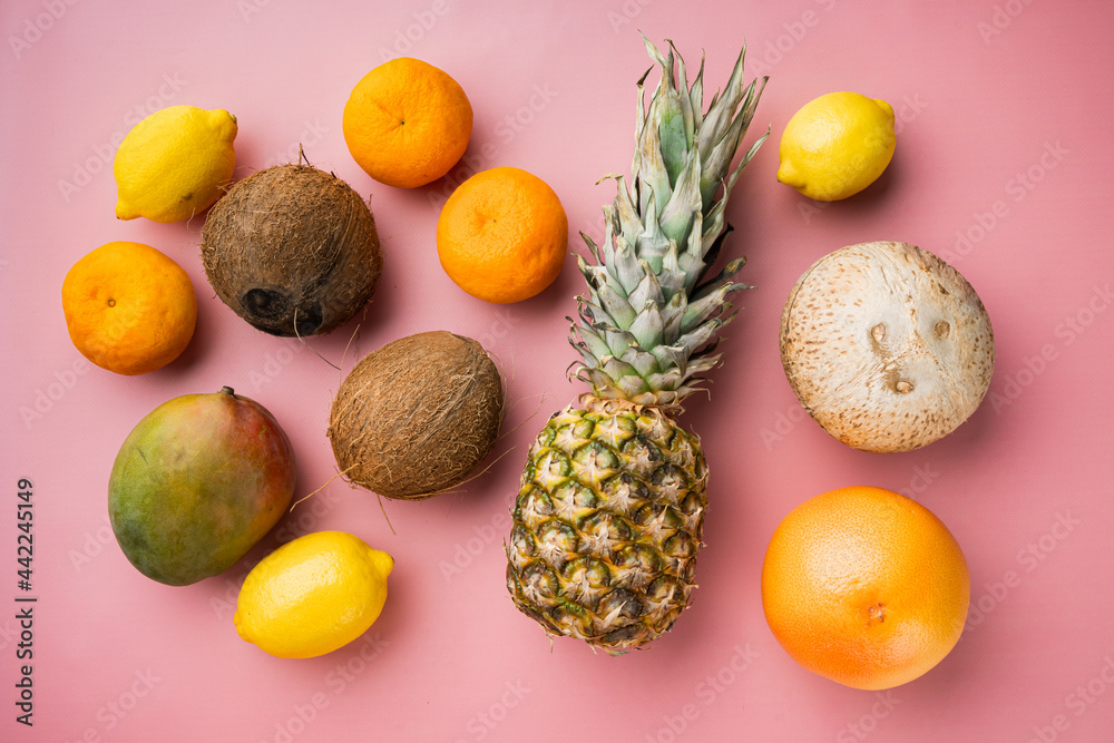 Fresh tropical fruit, on pink textured summer background, top view flat lay