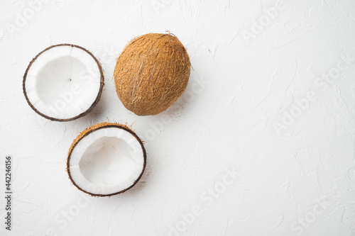Coconut cuts broken, on white stone table background, top view flat lay, with copy space for text