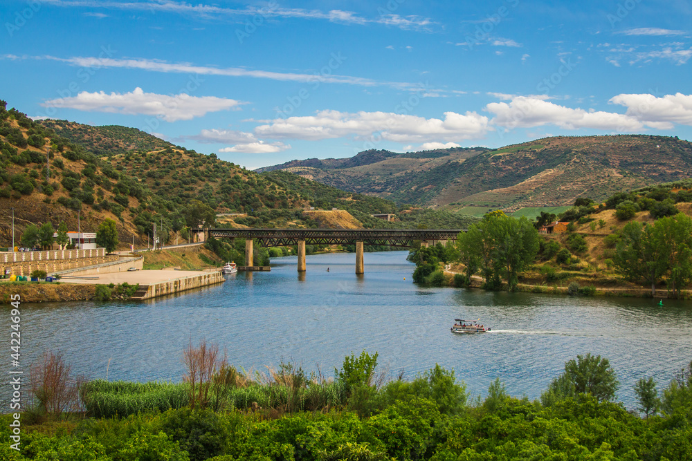Steel bridge over the Douro river, Portugal. Natural Park of the Douro river with beautiful mountain and river landscapes Steel bridge over the Douro river, Portugal. Natural Park of the Douro river with beautiful mountain and river landscapes