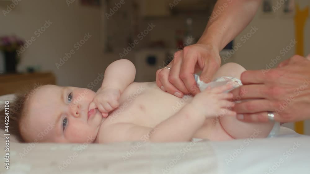 Diapering the baby to help newborn sleep better. Close up. Important to change diapers every two hours. Keeping the toddler longer than this period with a used diaper can cause infections or rashes.