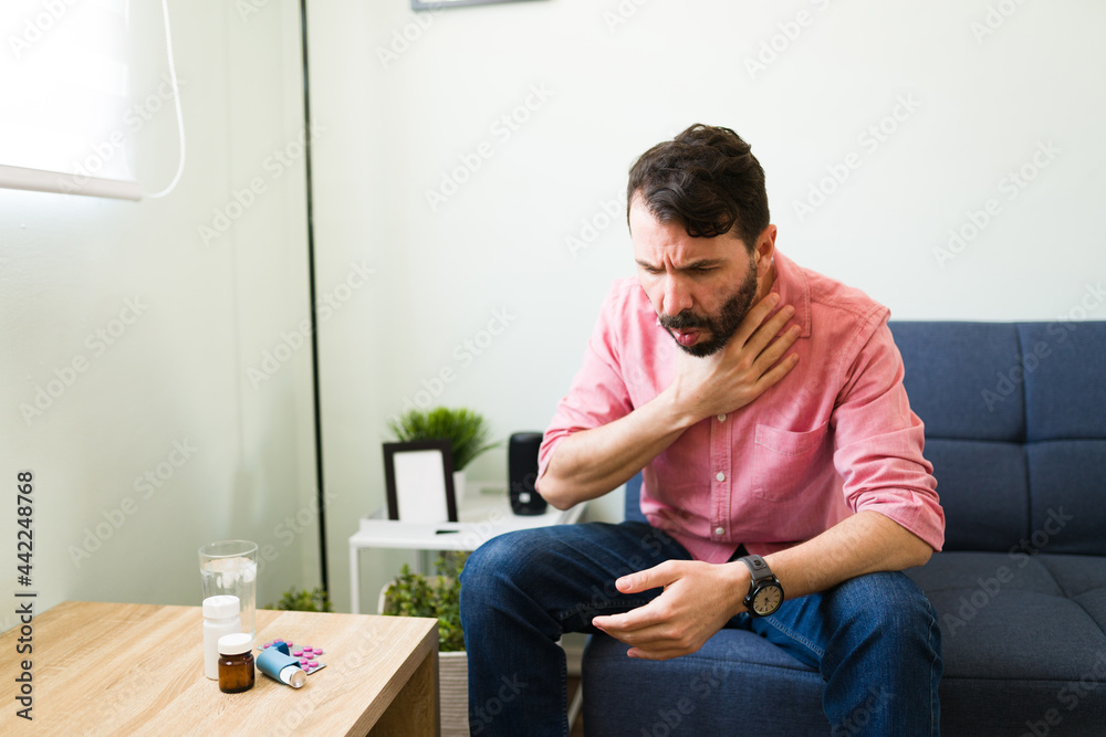 Stressed man taking his medicines at home