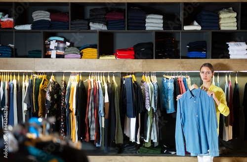 Young woman shopping clothes in modern men store