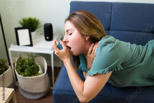 Young woman using an inhaler to breathe