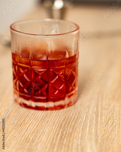 Front view of negroni cocktail in a glass tumbler on a wooden surface