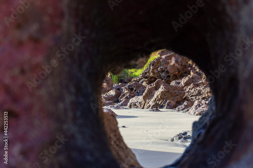 Buraco em rocha com vista para areia