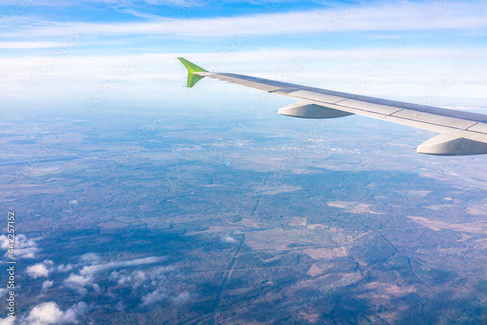 Fototapeta premium View from the airplane window at a beautiful blue sunrise and the airplane wing in clear sky.