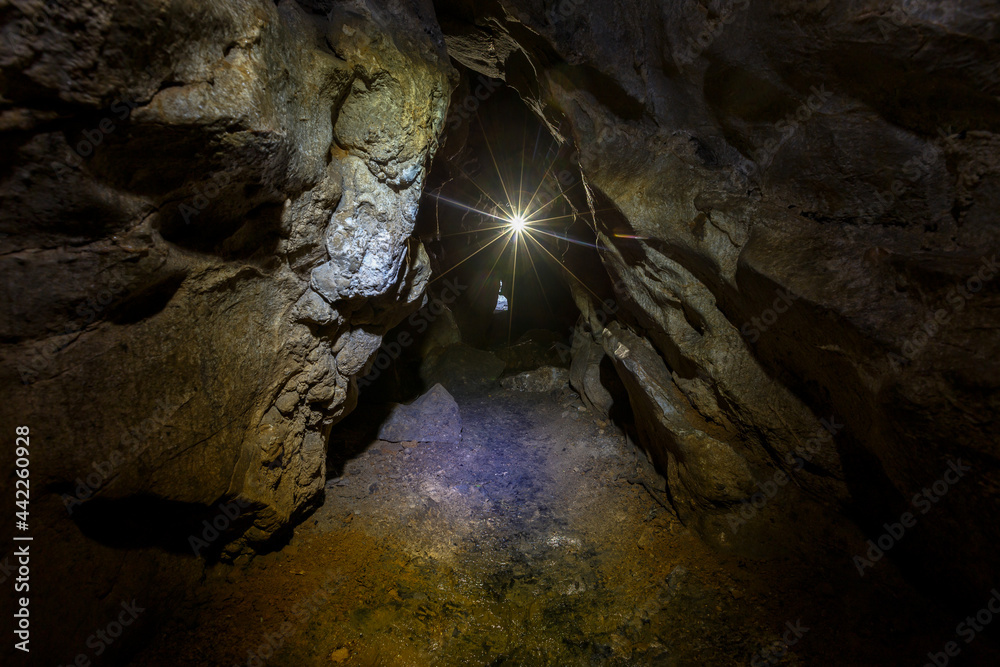 Chandolaz ridge cave in the Primorsky region. A deep cave illuminated by a flashlight.