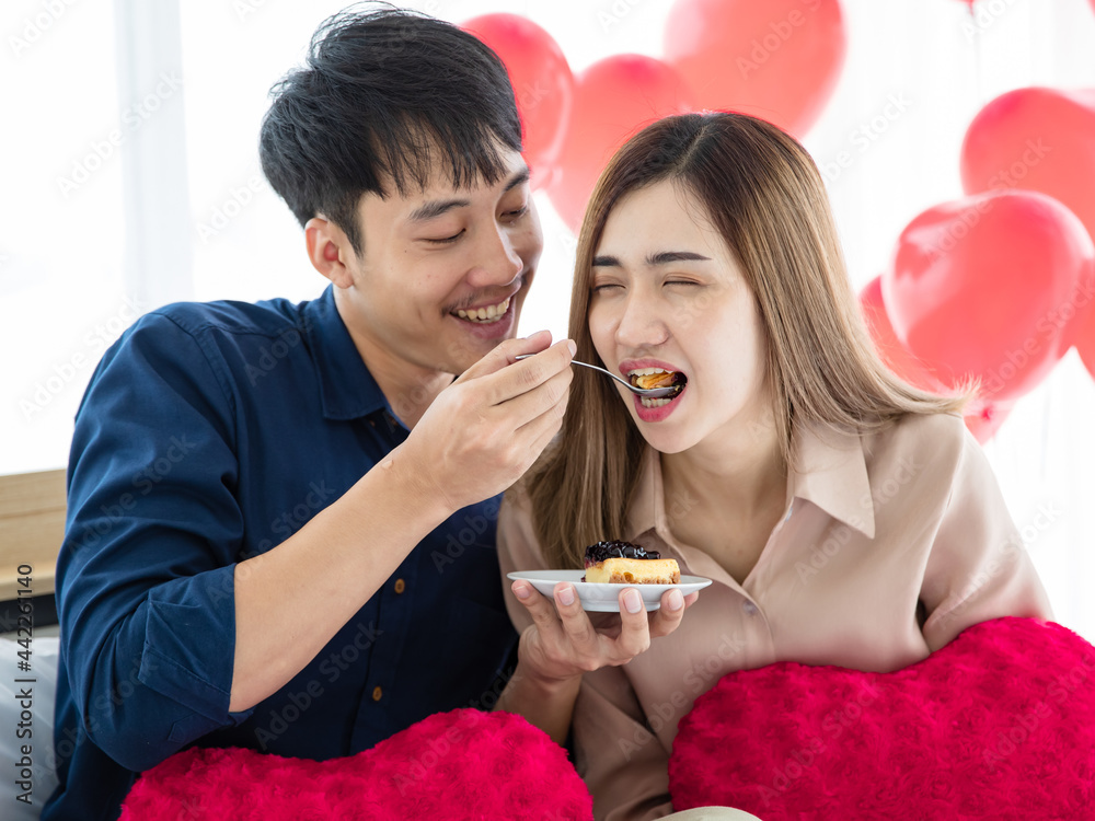 Asian man feeding girlfriend with cake Asian man feeding girlfriend with cake