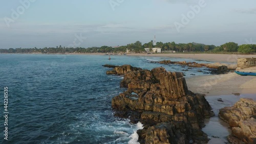 Rocky calm shore of Sri Lanka Salli beach tropical island at dawn photo