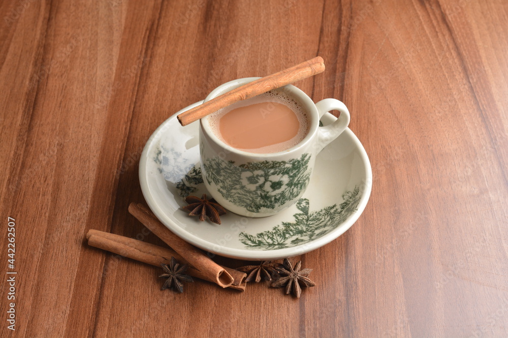 hot masala chai milk tea in traditional ceramic cup with cinnamon and star anise on wood table hot healthy asian beverage menu hot masala chai milk tea in traditional ceramic cup with cinnamon and star anise on wood table hot healthy asian beverage menu