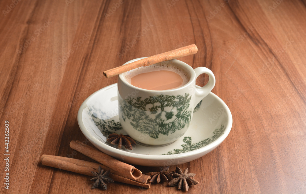 hot masala chai milk tea in traditional ceramic cup with cinnamon and star anise on wood table hot healthy asian beverage menu hot masala chai milk tea in traditional ceramic cup with cinnamon and star anise on wood table hot healthy asian beverage menu