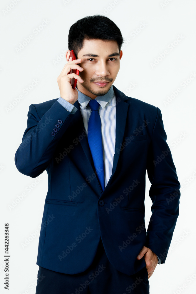 Portrait of focused young Asian businessman talk on the phone on isolated white background. Studio shot, business communication concept. Portrait of focused young Asian businessman talk on the phone on isolated white background. Studio shot, business communication concept.